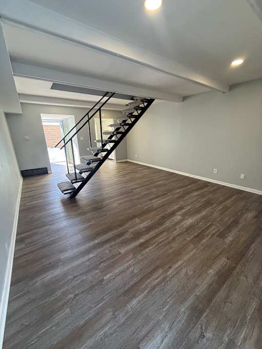 A staircase with a wooden floor and a metal railing.