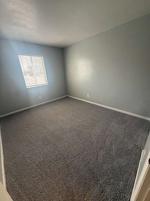 A small window in a room with a grey wall.