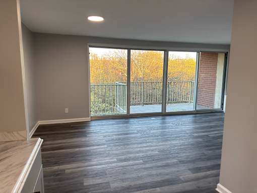 A room with a sliding glass door leading to a balcony.