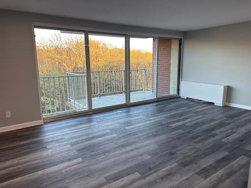 A room with a large window and sliding glass doors.