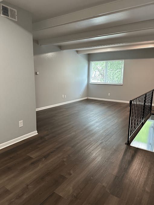 A room with wooden flooring and a window.