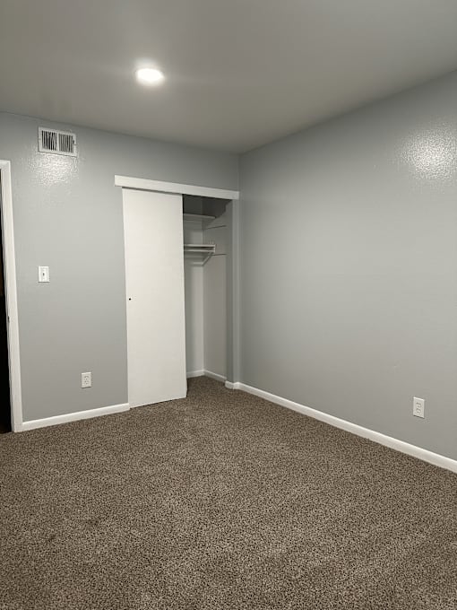 A room with a carpeted floor and a white door.