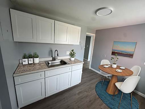 A kitchen with white cabinets and a brown countertop.at The Summit, Syracuse, NY 13210