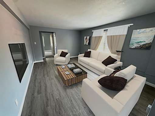 A modern living room with a white sofa and a wooden coffee table.at The Summit, Syracuse, 13210
