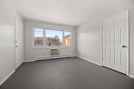 A room with a large window and a view of a building outside.