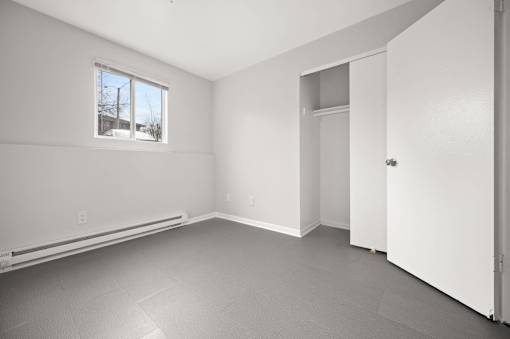 A room with a window, a door, and a wall socket.