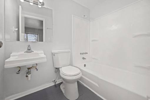 A white toilet and sink in a bathroom.