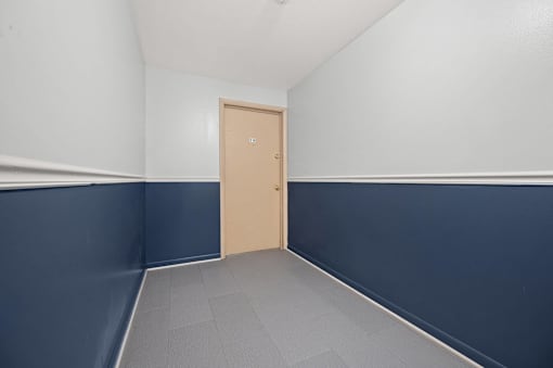 A room with a closed door and a grey floor.
