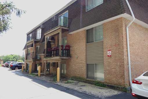 A red and white sign is on the side of a brick building.