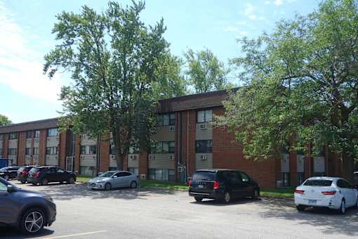 A parking lot with cars and a building in the background.