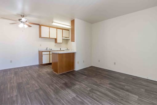 an empty living room with white walls and wood flooring