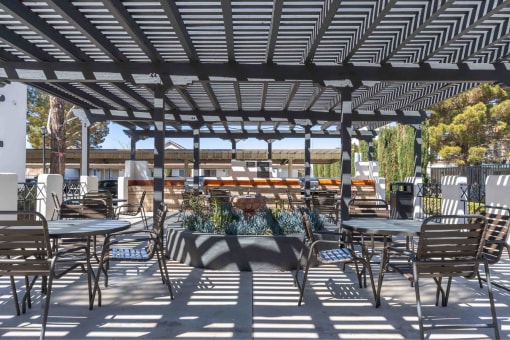 a patio with tables and chairs and a pergola