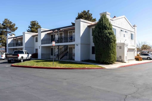 a white apartment building with a parking lot