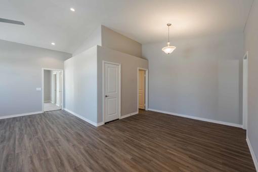 A room with wooden flooring and white walls.