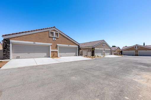 A row of houses with garages and driveways.