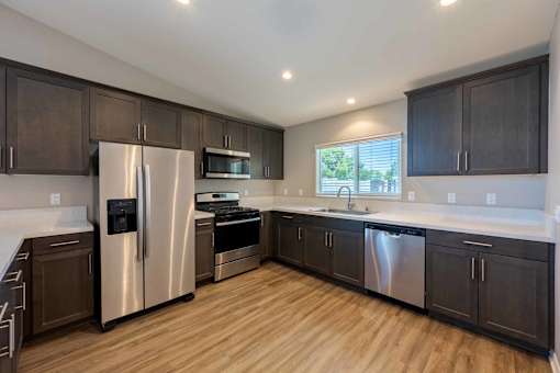 A kitchen with dark wood cabinets and stainless steel appliances.