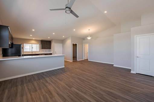A spacious room with wooden flooring and a ceiling fan.