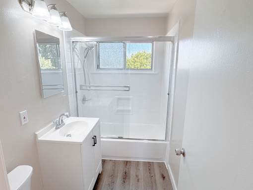 Willow Manor 1bed 1 bath floorplan - bathroom with a window, toilet, sink, and shower/tub.