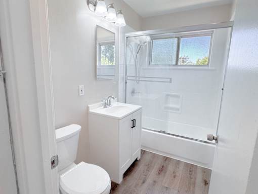 Willow Manor 1bed 1 bath floorplan - bathroom with a window, toilet, sink, and shower/tub.