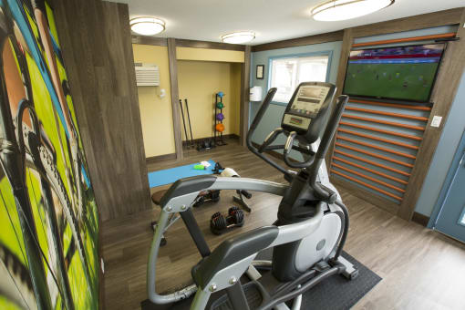 fitness center with elliptical and tv at Abby Creek Apartments, Carmichael 