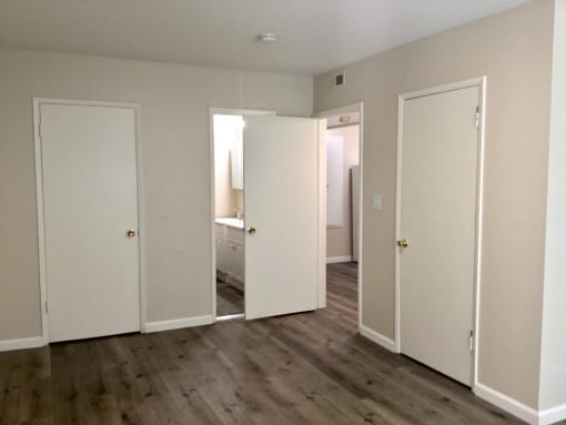 Bedroom with white doors and a wood floor