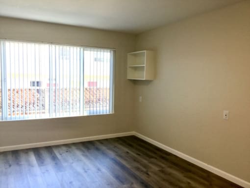 Bedroom with a large window and wooden floors