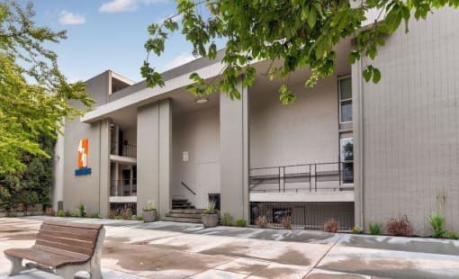 470 Apartments building with logo and bench on sidewalk