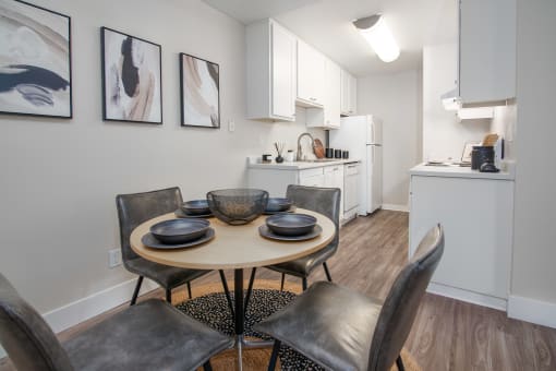 Model Apartment dining room with a table and chairs and a kitchen at Rivercrest Apartments, Sacramento 