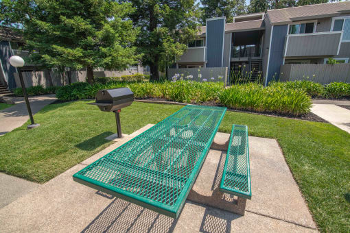 BBQ and Picnic table and benches in front of an apartment building at Willow Grove Apartments, Sacramento