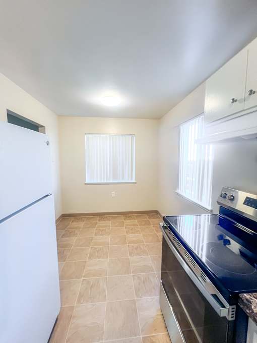 Monterey Manor vacant apartment kitchen and dining room with vinyl, a stover and fridge
