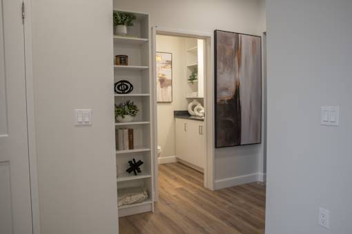 A white door is open to a hallway with a framed picture on the wall.
