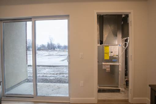 A room with a window and a door to the outside with snow on the ground.