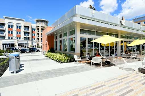 A sunny day at the outdoor seating area of a restaurant with yellow umbrellas.