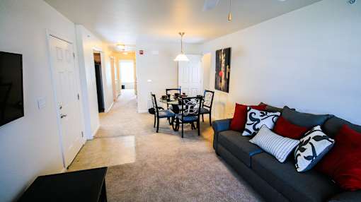 A living room with a grey couch and a black coffee table.