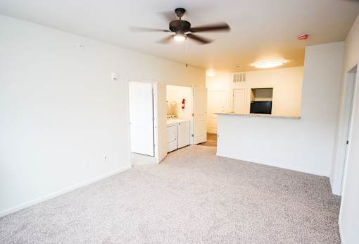 A room with a ceiling fan and a doorway leading to another room.