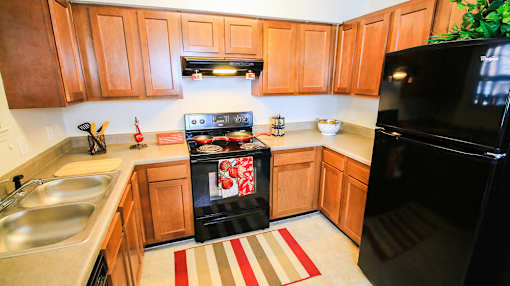 A kitchen with wooden cabinets and a black oven.