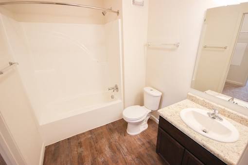 A white toilet sits next to a sink in a bathroom.