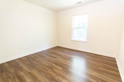 A room with wooden flooring and a window.