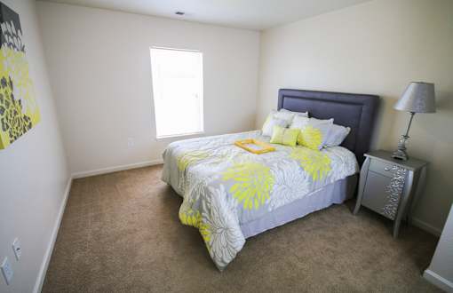 A bedroom with a bed, nightstand, and lamp.