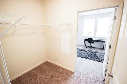 A room with a carpeted floor and a white door leading to another room.