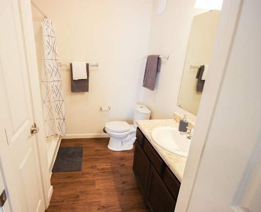 A white toilet sits in a bathroom next to a sink.