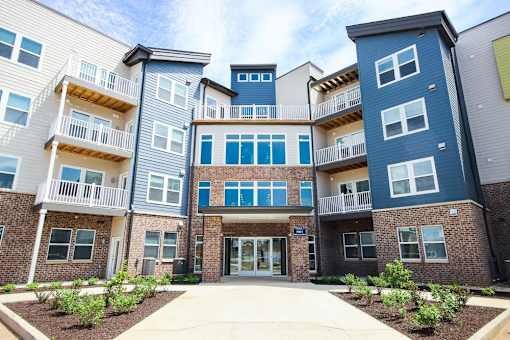 A modern apartment complex with multiple balconies and doors.