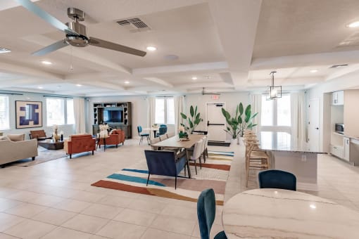 a living room with tables and chairs and a ceiling fan at Swiftwater apartments in Port Charlotte, FL
