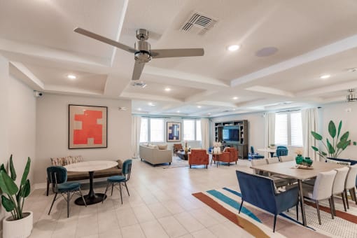a living room with tables and chairs and a ceiling fan at Swiftwater apartments in Port Charlotte, FL