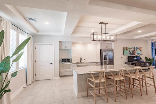 Community kitchen at Swiftwater apartments in port charlotte with a marble counter top island and chairs