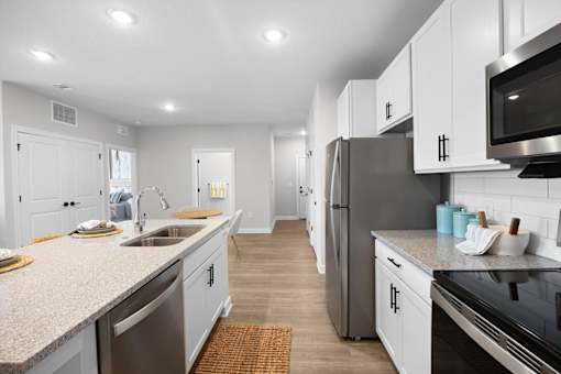 A modern kitchen with stainless steel appliances and white cabinets.