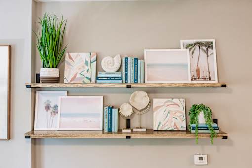 a wall shelf with books and pictures and plants on it