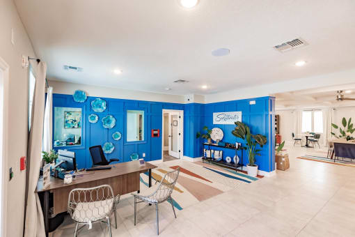 living room area at swiftwater apartments clubhouse with blue walls and a table