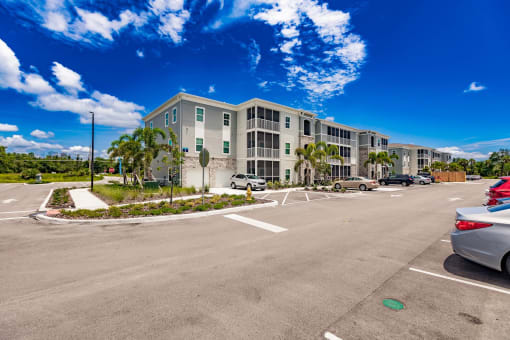 an empty parking lot in front of swiftwater apartment building with palm trees