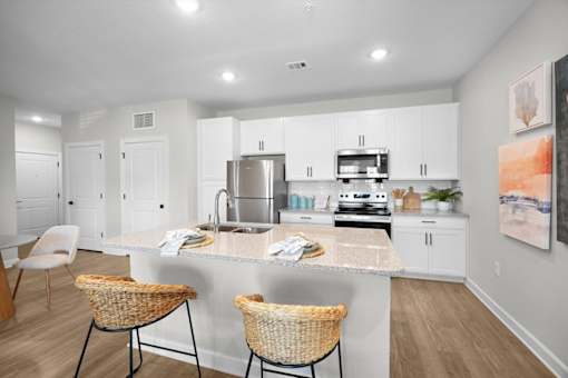 A kitchen with a white countertop and a sink.